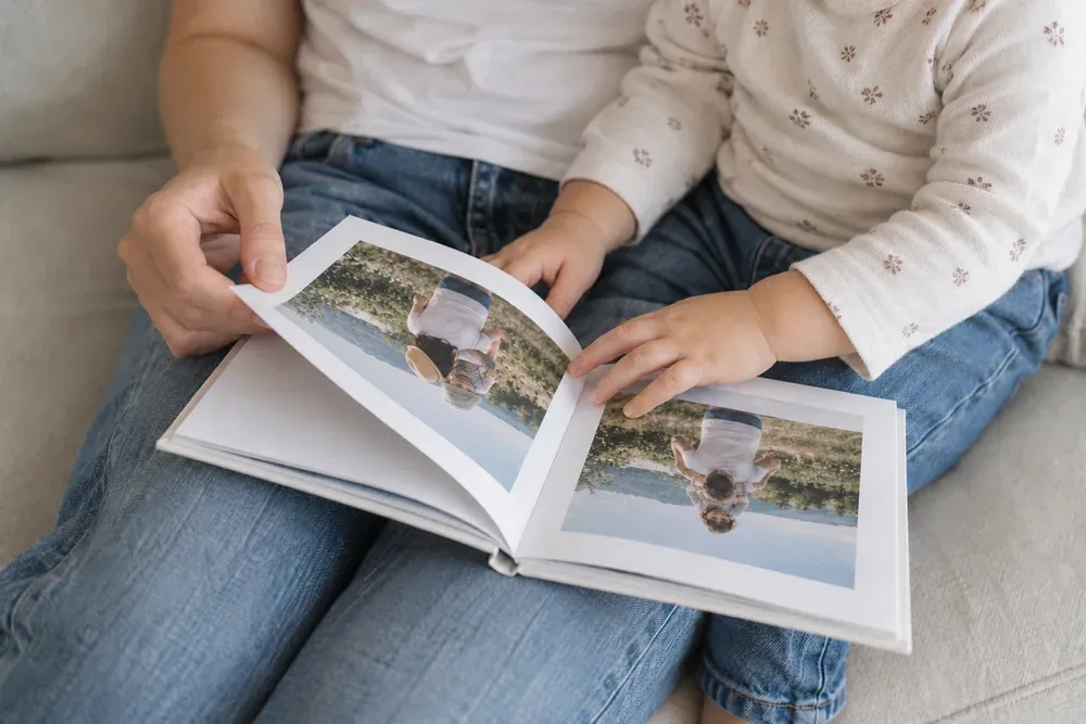 Une maman et son enfant feuillettent un livre photo